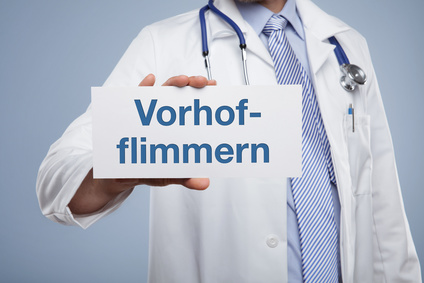 A doctor is holding a card that says “atrial fibrillation.”
