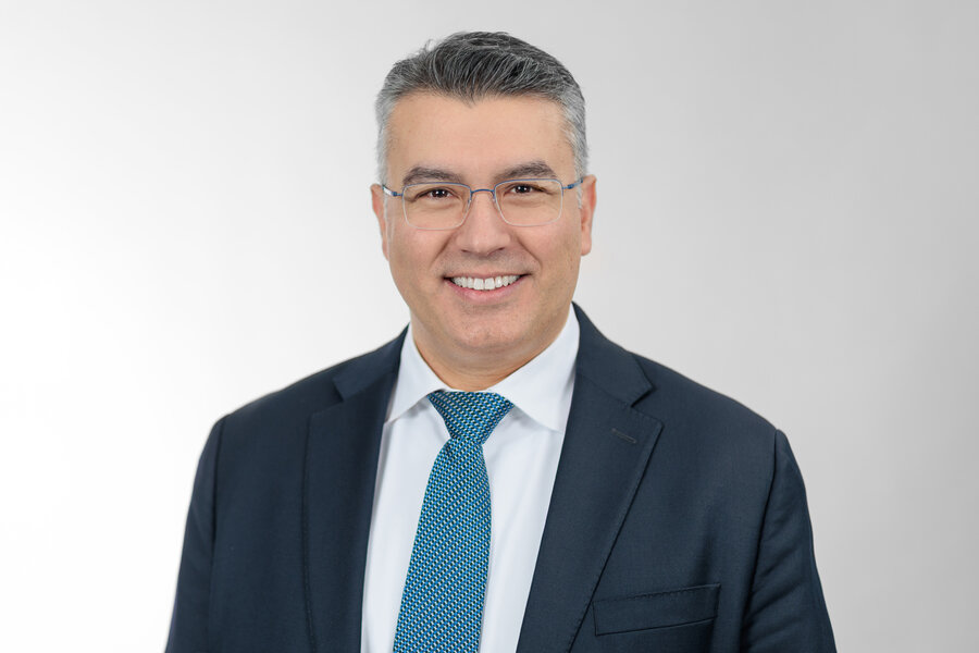 A man in a suit smiling at the camera.
