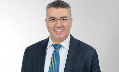 A man in a suit smiling at the camera.