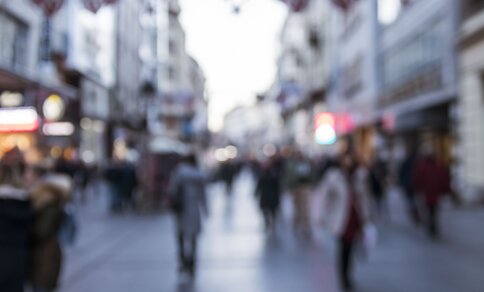 A blurred scene with pedestrians in a busy pedestrian zone.