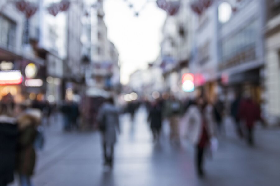 A blurred scene with pedestrians in a busy pedestrian zone.