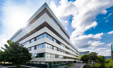  Ein mit weißen und grauen Paneelen gebautes Gebäude, das einen klaren und anspruchsvollen architektonischen Stil widerspiegelt.