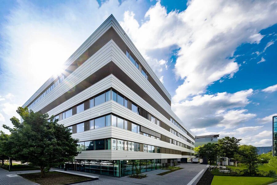  A building constructed with white and gray panels, reflecting a clean and sophisticated architectural style.  