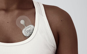 Woman with mobile rhythm patch on her chest. 