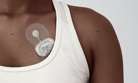 Woman with mobile rhythm patch on her chest. 