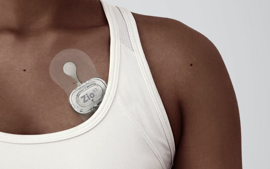 Woman with mobile rhythm patch on her chest. 